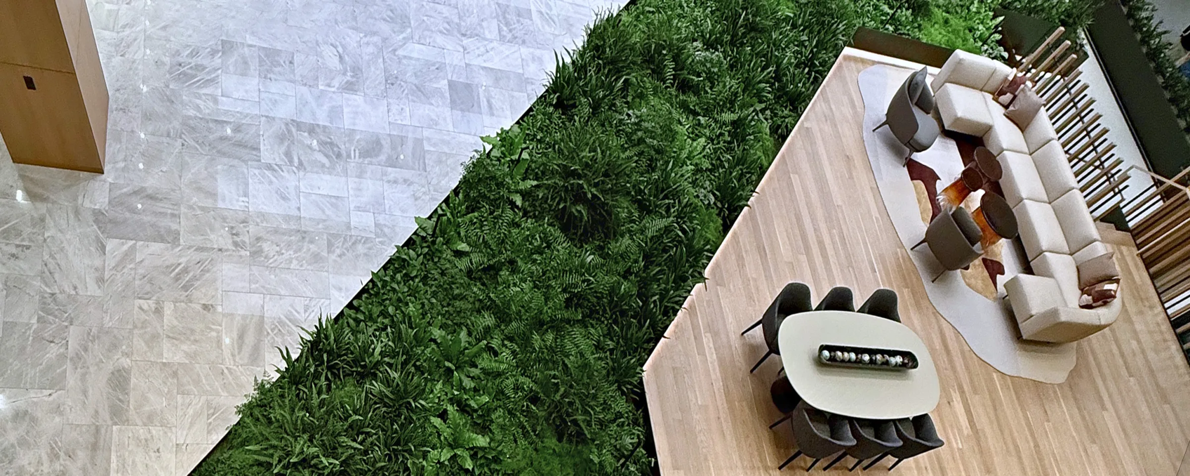 Overhead view of a PhytoMat installation in a commercial lobby, a large planted bed running alongside a wood seating platform