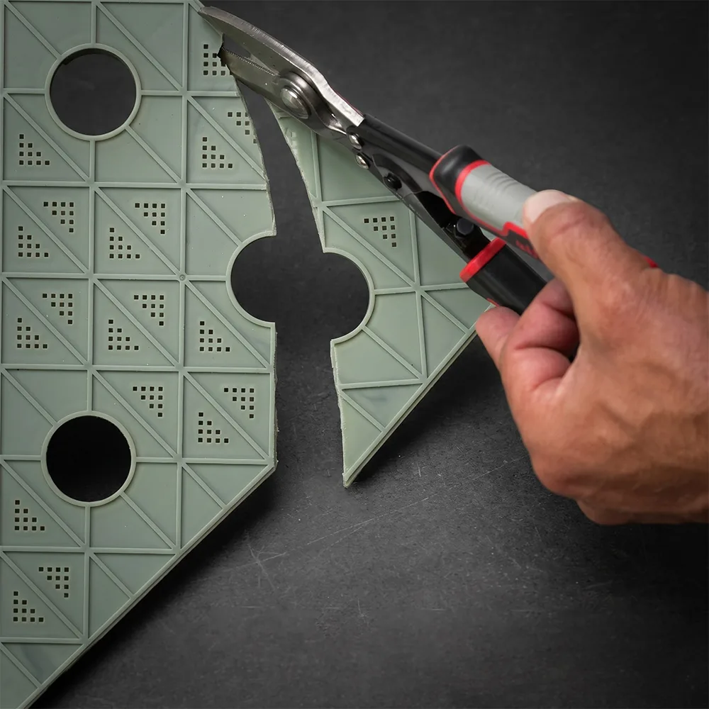 Trim-to-Fit PhytoMat tile being cut to fit a curved planter
